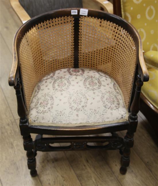 A 1920s caned back tub shaped armchair